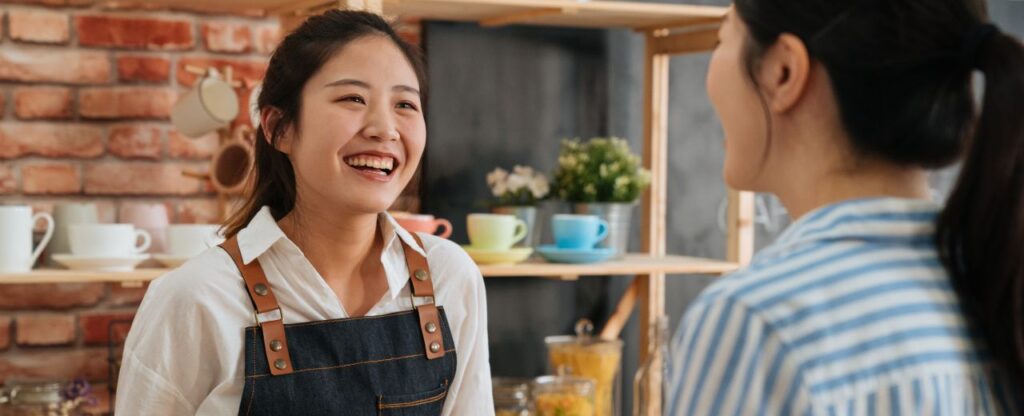 Pottery studio employee chats with customer about pottery class